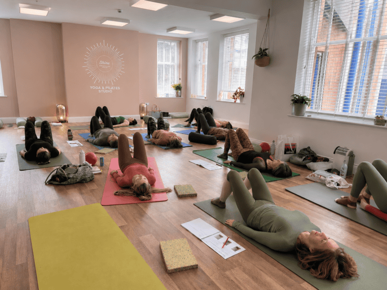 A group of people taking part in a yoga workshop at Shine At The Hollies