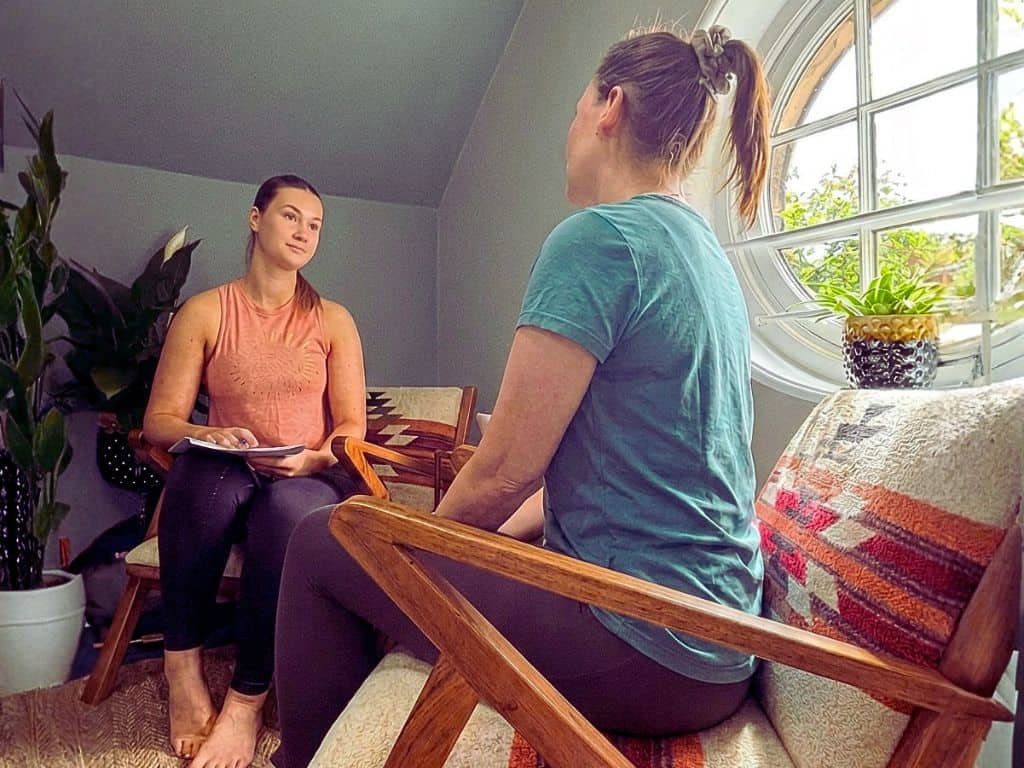 Lauren, Sports Therapist, having a consultation with a client in the Shine Wellbeing treament room