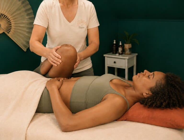 a woman laying on the treatment bed at Shine at The Hollies receiving follow-up rehabilitation therapy from Lauren the sports therapist