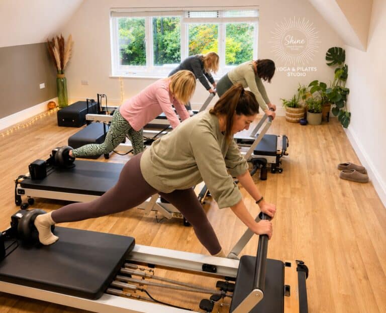 group of women working on standing movement exercises on the Reformer machines at Shine at The Hollies as part of the Reformer Pilates Teacher Training Course