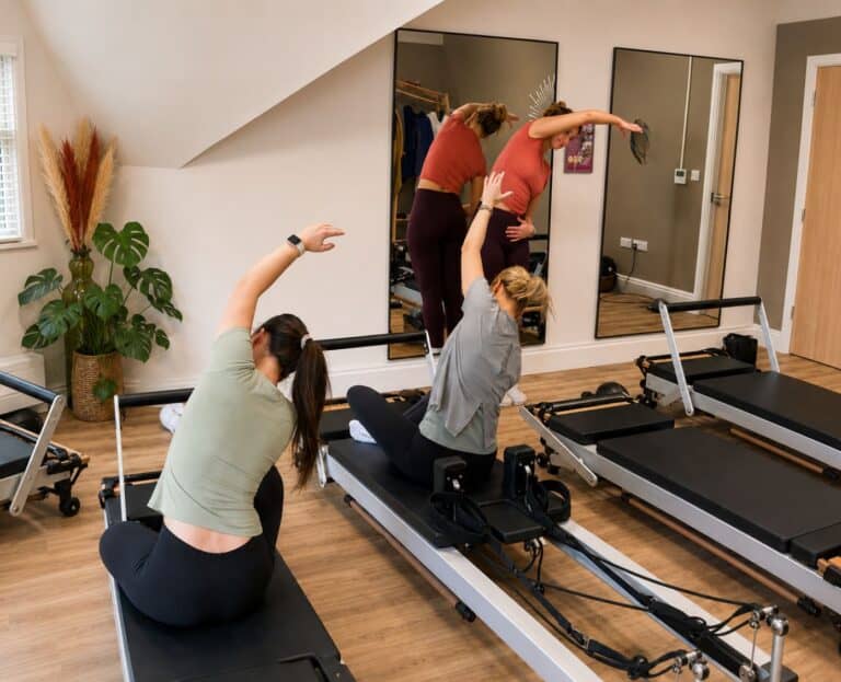 Teacher at Shine at The Hollies demonstrating movement in the Reformer Pilates Teacher Training Course
