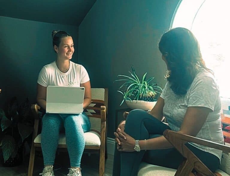 Lauren Sports Therapist at shine at The Hollies sitting with a client having a consultation